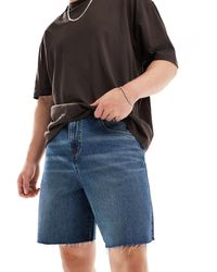 ASOS - Jorts di jeans taglio standard con fondo grezzo lavaggio medio - Lyst