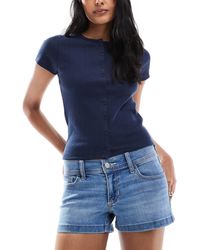 Hollister - Mini-short en jean à taille basse et ourlet fendu - moyen délavé - Lyst