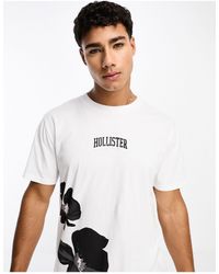 Hollister - T-shirt bianca con stampa a fiori e logo centrale - Lyst