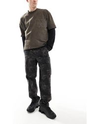 River Island - – weite cargo-hose mit military-muster auf dunklem grund - Lyst