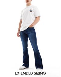 ASOS - Jeans a zampa elasticizzati lavaggio scuro - Lyst
