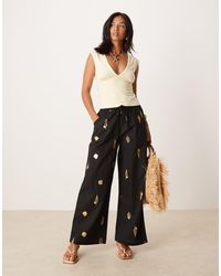 Never Fully Dressed - Pantalones Negros De Pernera Ancha Con Conchas Doradas De Petite - Lyst