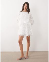 TFNC London - Robe babydoll courte à plumes synthétiques et manches cloche - blanc - Lyst