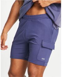 Pantalones cortos deportivos ajustados con bolsillos cargo ASOS 4505 de Tejido sintético de color Azul para hombre Hombre Ropa de Pantalones cortos de Bermudas cargo 