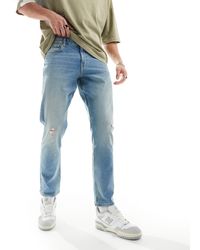 ASOS - Jeans slim elasticizzati lavaggio chiaro con abrasioni - Lyst