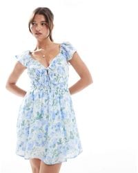 Hollister - – kurzärmliges mini-skater-kleid mit blumenmuster und gesmokter taille - Lyst