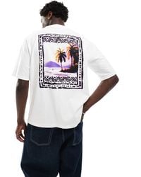 Levi's - Camicia a mezze maniche comoda bianca con logo e paesaggio con palme sul retro - Lyst