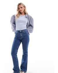 ASOS - Asos Design Petite Mid Rise Flare Jeans - Lyst