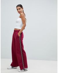 ASOS Joggers con pernera ancha con cinta lateral y volante - Rojo