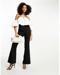 In The Style - Tuta jumpsuit con maniche a sbuffo e scollo bardot con pantaloni a zampa bianca e nera - Lyst