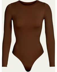 Skims - Essential Smoothing Long-sleeve Thong Bodysuit - Lyst