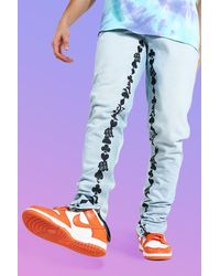 BoohooMAN Tapered Stacked Leg Graphic Print Jeans - Blue