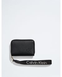 Calvin Silver Wristlet Clutch in Metallic | Lyst
