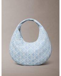 Calvin Klein - Allover Emblem Logo Denim Crescent Bag - Lyst