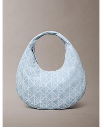 Calvin Klein - Allover Emblem Logo Denim Crescent Bag - Lyst