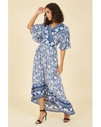 Yumi' - Blue Border Floral Print Wrap High Low Maxi Dress - Lyst