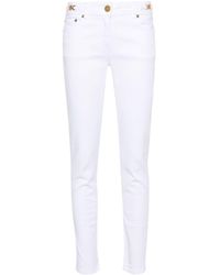 Versace - Jeans skinny con placca Medusa - Lyst