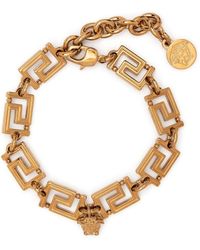 Versace - Bracciale greca in metallo dorato donna - Lyst