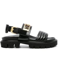 Moschino - Schwarze gesteppte sandalen mit goldenem logo - Lyst