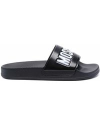 Moschino Fluweel Slippers Met Logoprint in het Zwart Dames Schoenen voor voor Platte schoenen voor Sandalen en teenslippers 