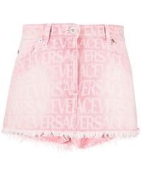 Versace - Jupe-short rose en denim à motif à logo - Lyst