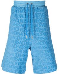 Versace - Pantalones cortos Allover con logo en relieve - Lyst