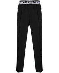 Versace - Pantalones slim con logo en la cinturilla - Lyst