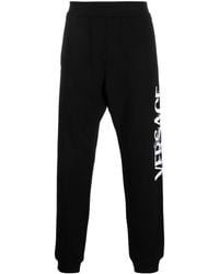 Versace - Logo-embroidered track pants - Lyst