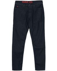 HUGO - Jeans affusolati con placca logo - Lyst