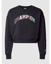 Champion Cropped Sweatshirt mit Label-Schriftzug in Glanz-Optik - Schwarz