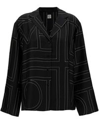 Totême - Camicia con stampa monogramma all-over in seta nera donna - Lyst