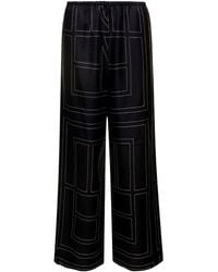 TOTEME - Pantaloni morbidi con stampa monogramma in seta nera donna - Lyst