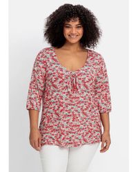 Sheego - T-Shirt Große Größen mit Allover-Blumendruck und tiefem Ausschnitt - Lyst