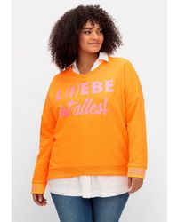 Sheego - Sweatshirt Große Größen mit Neon-Print und Seitenschlitzen - Lyst