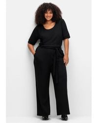 Sheego - Jumpsuit Große Größen mit Bindegürtel und weitem Bein - Lyst