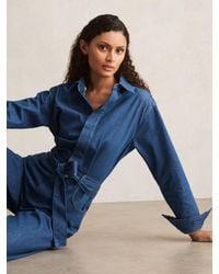 PAIGE - Wide Leg Belted Denim Jumpsuit - Lyst