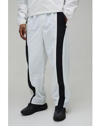 BoohooMAN - Relaxed Fit Curve Panel And Binding Toggle Hem Nylon Trousers - Lyst