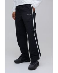 BoohooMAN - Relaxed Fit Side Stripe Logo Print Nylon Trousers - Lyst