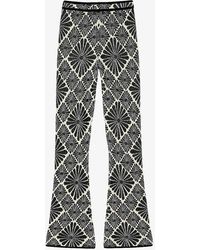 Sandro - Floral-print Flared-leg Stretch-knit Trousers - Lyst