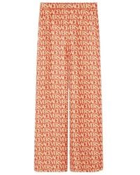 Versace - Logo Printed Wide Leg Trousers - Lyst