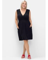 Sheego - Ärmelloses Kleid in Wickeloptik mit gesmokten Details - Lyst