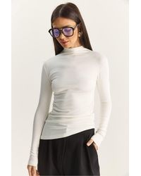 Bianco Lucci - Fitted Turtleneck Long Sleeve Blouse With Ruffle Detail - Lyst