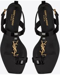 Saint Laurent Cassandra Flat Sandals In Patent Leather With Gold-tone Monogram - Black