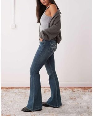Monki Katsumi Low Waist Flare Jeans With Bow Embellishment - Blue