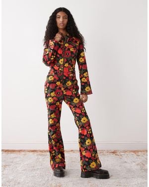 Wrangler – jeans-jumpsuit im retro-design mit rotem und gelbem blumenmuster