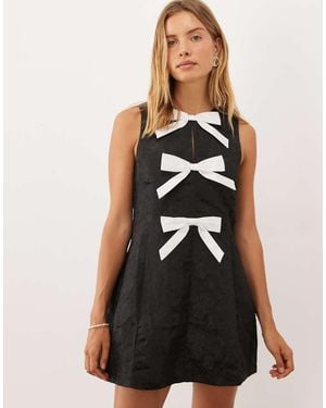 Sister Jane Nova Jacquard Jurk Met Ronde Hals, Mouwloos, Strikapplicatie, Mini - Zwart