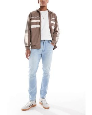 Wrangler – larston – schmal zulaufende jeans mit schmalem schnitt - Blau