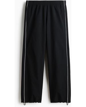 H&M Track Pants mit Print in Relaxed Fit - Schwarz