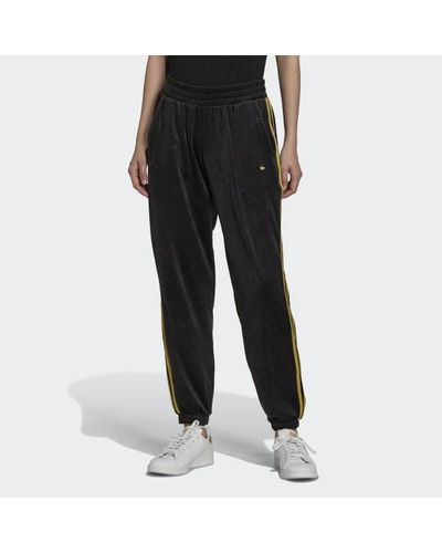 black adidas pants with gold stripes