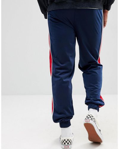 navy blue track pants with red stripe